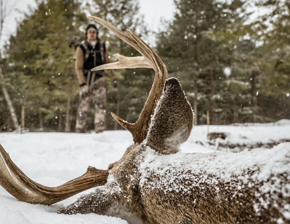 A hunter approaches a trophy deer