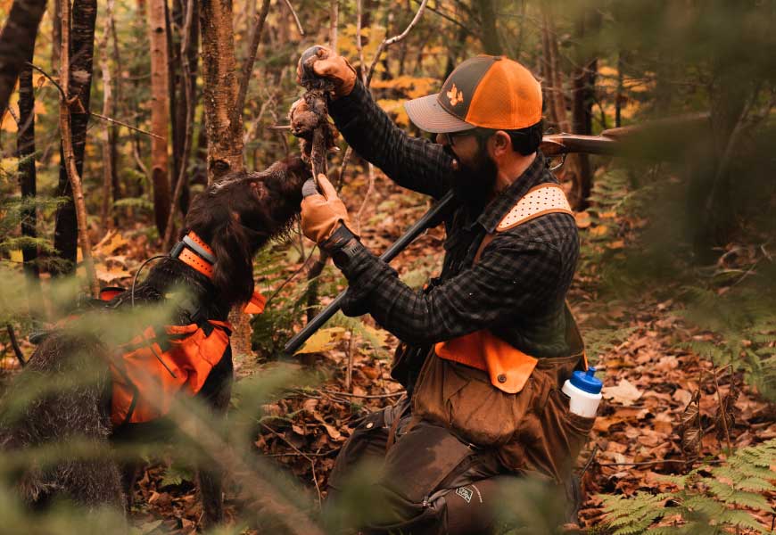 A millennial hunter with his bird dog on a woodcock hunter.